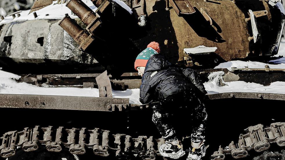 Leben in Zeiten des Krieges: Ein Kind klettert auf einem zerstörten Panzer herum.. Foto: IMAGO/Funke Foto Services
