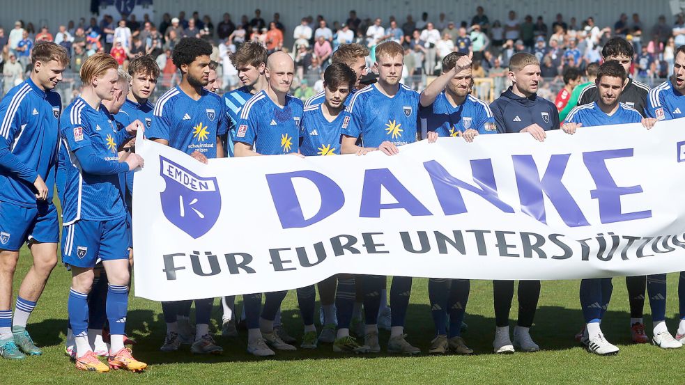 Vor dem letzten Heimspiel der Saison 2024/25 gegen Eintracht Norderstedt bedankte sich die Emder Mannschaft mit einem Banner bei den Fans. Mehrere Spieler liefen an jenem Tag letztmals im Ostfriesland-Stadion auf – darunter David Kébé (vor dem linken Kickers-Wappen) und Tim Dietrich (rechts daneben). Fotos: Jens Doden, Emden