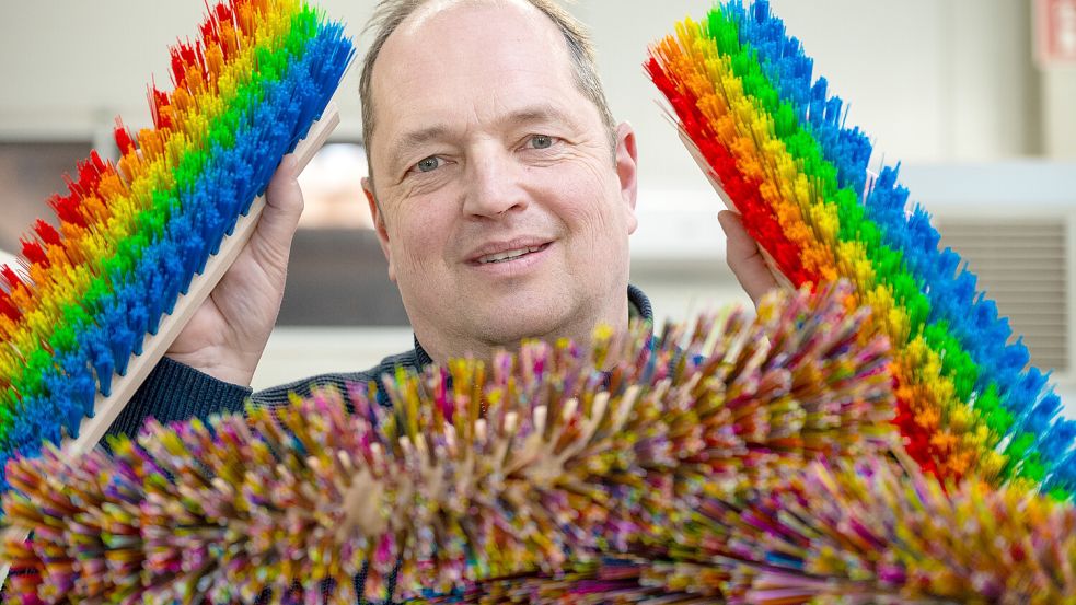 Michael Andreas und die bunten Besen, die zum viralen Erfolg wurden. Foto: Klaus Ortgies