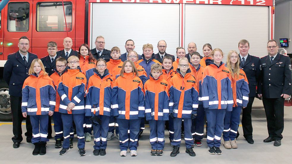 Die Jugendfeuerwehr Weener stellte sich auf der Jahreshauptversammlung mit Führungskräften und Gästen zum Foto auf. Jonas Bruns (hintere Reihe, 2. von links) ist einer von zwei Jugendlichen, die zu den Einsatzkräften wechselten. Foto: Feuerwehr/Joachim Rand