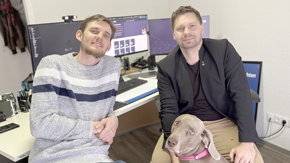 Marco Hoffmeier (links) und Bernd Dettmers teilen sich mit Bürohund Caesar ein Büro in Aurich. Foto: Eva van Loh