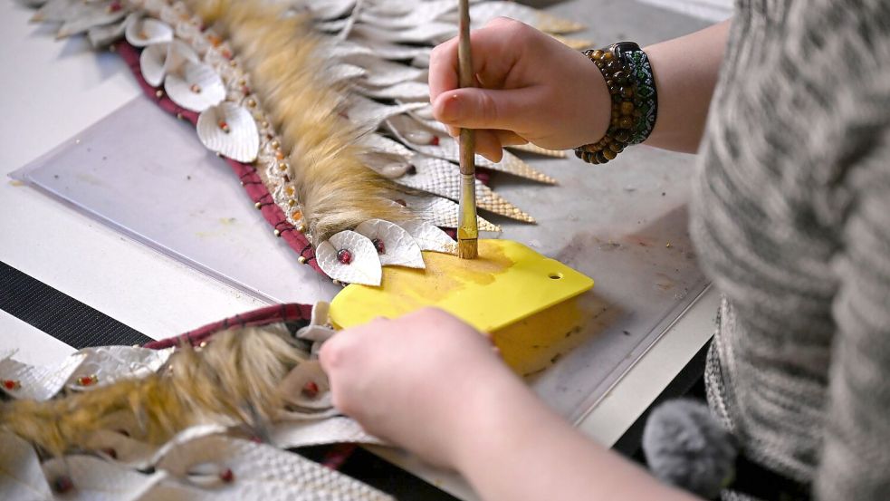 Mit Pinsel und goldener Farbe bemalt Toni ihr Kostüm. Foto: Jennifer Brückner