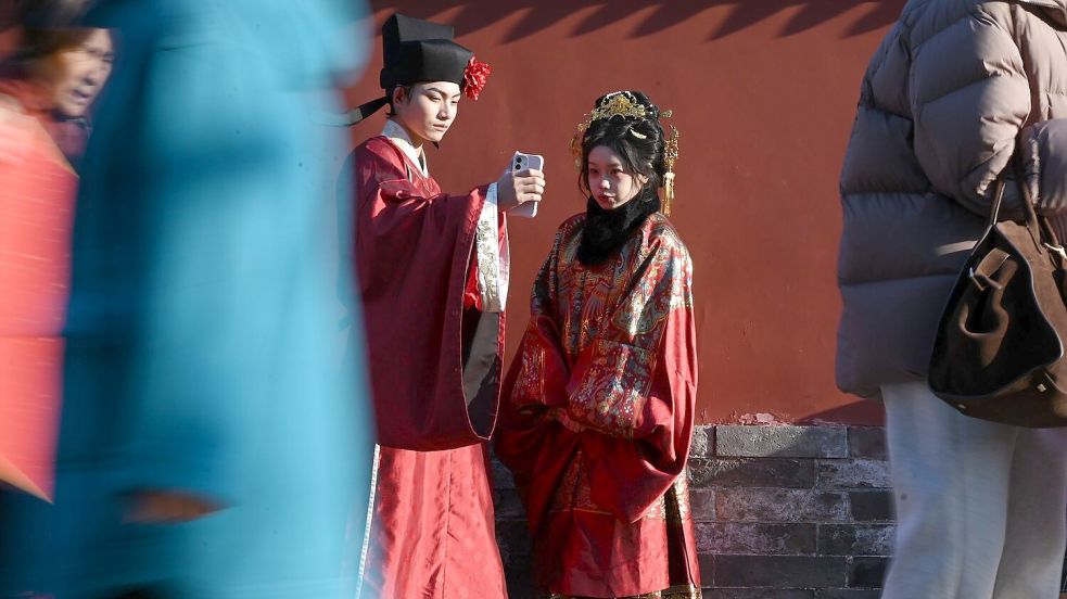 In traditioneller Kleidung vor dem Trommelturm in Peking. Chinesische Bräuche sind im Netz aktuell angesagt. Foto: Johannes Neudecker