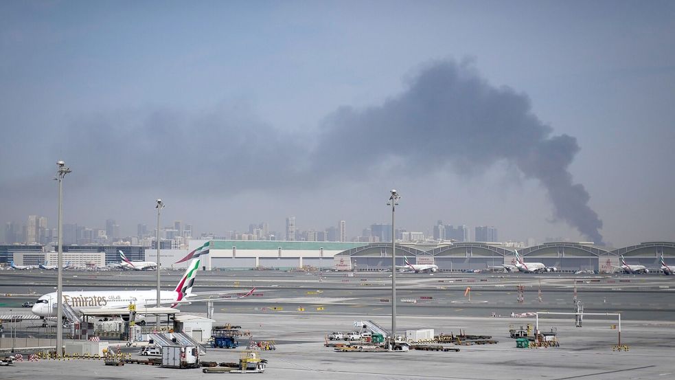 Nach einem iranischen Angriff ist am Flughafen von Dubai eine Rauchwolke zu sehen. Foto: Altaf Qadri/AP/dpa