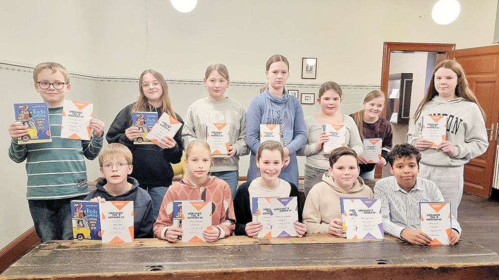 Die Teilnehmer am Vorlese-Kreisentscheid, Siegerin Amelie Brickwedde (sitzend, Mitte) und der Zweitplatzierte Udo Wallenstein (rechts daneben) freuen sich über ihre Urkunden. Foto: Käthe Dübbel