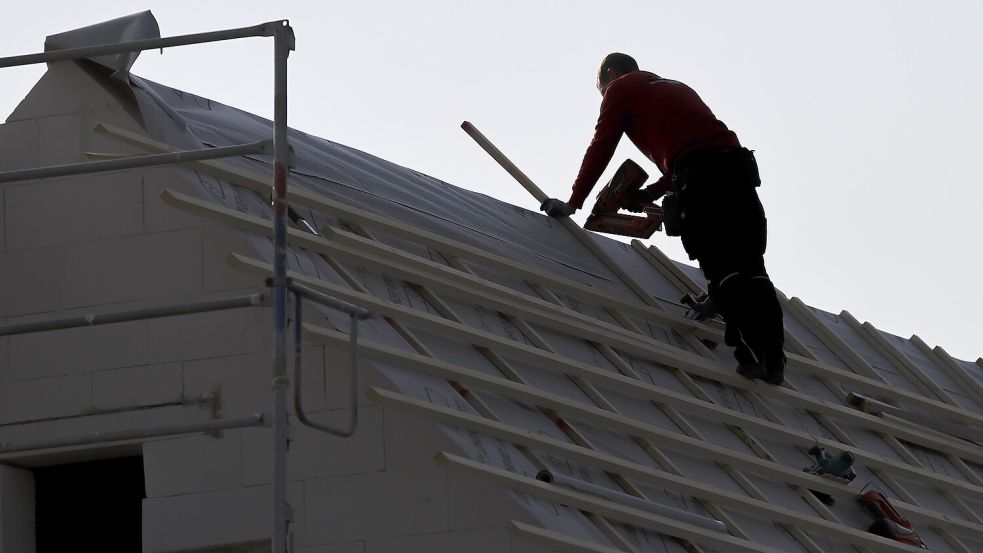 Ein Dachdecker arbeitet auf einem Einfamilienhaus: Die Vorschriften fürs Bauen sind kompliziert. Symbolfoto: Jan Woitas/dpa