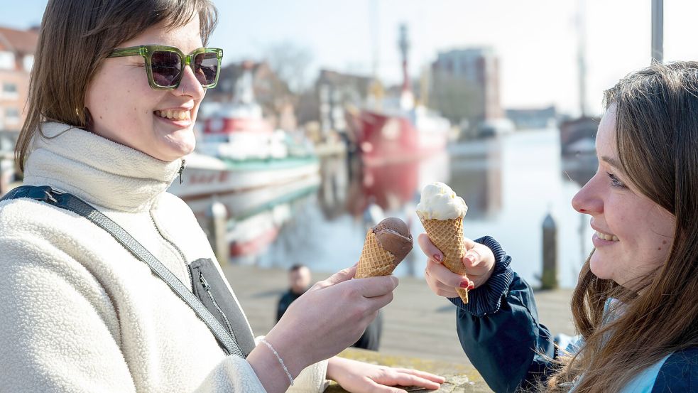 Die OZ-Redakteurinnen Hannah Weiden (links) und Lotta Groenendaal genießen ihr erstes Eis in der Sonne am Emder Delft. Foto: Klaus Ortgies