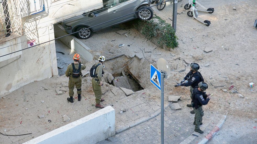 Nach einem Raketeneinschlag in Tel Aviv sind Anwohner schockiert. Foto: Ohad Zwigenberg/AP/dpa