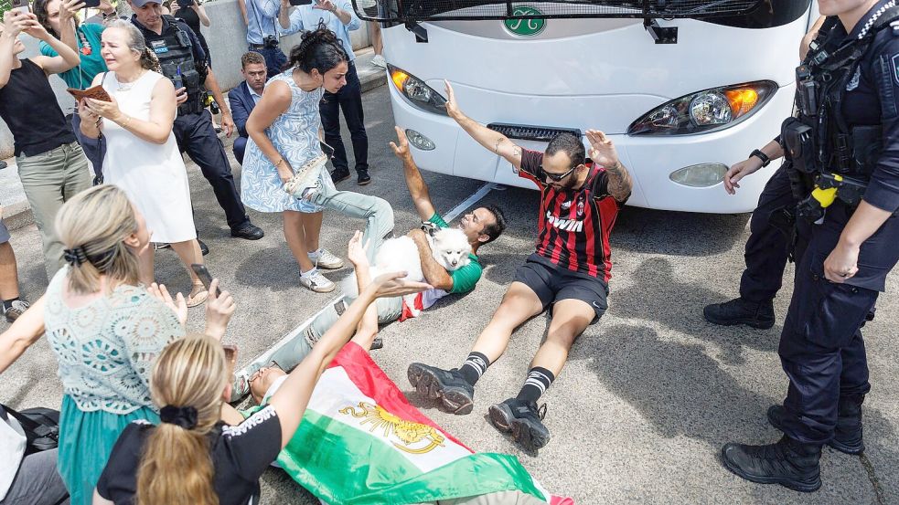 Demonstranten protestierten, während der Bus mit iranischen Spielerinnen und Mitarbeitern abfuhr. Foto: Russell Freeman/AAP/dpa