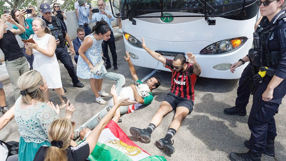 Demonstranten protestierten, während der Bus mit iranischen Spielerinnen und Mitarbeitern abfuhr. Foto: Russell Freeman/AAP/dpa