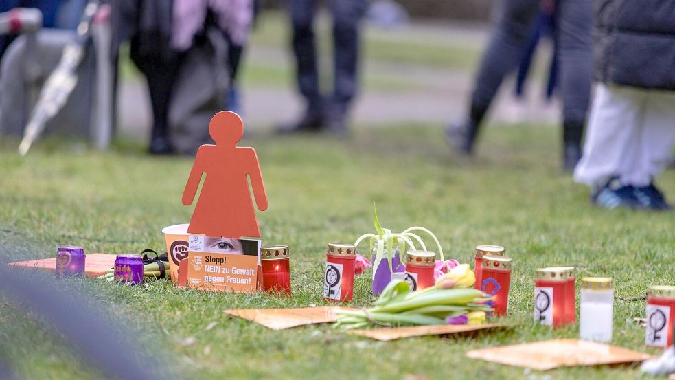 Die Versammelten legten am Willy-Brandt-Platz Blumen und Kerzen für die getötete Frau in Wallenhorst nieder. Foto: Sebastian Dannenberg