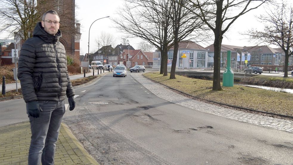 Philipp Jakobi, Bauingenieur des Ammerländer Straßenbauunternehmens Georg Koch, steht am Rhauderfehner Kreisel. Der ist von vielen Schlaglöchern übersät – eine ganz typische Situation nach der Frostperiode. Im Frühsommer 2026 soll der Kreisel saniert werden. Das geschieht im Zuge der Sanierung des nördlichen Untenendes. Die Kosten werden vom Bund getragen. Der Kreisel ist Teil der Bundesstraße 438, einer der meistbefahrenen Straßen im Landkreis Leer. 9000 Fahrzeuge täglich werden hier durchschnittlich gezählt. Foto: Astrid Fertig