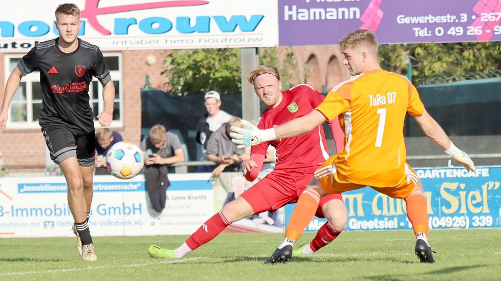 Das Hinspiel in Pewsum gewann der heimische TuS. Marek Hinrichs (Mitte, im roten Trikot) erzielte gegen Westrhauderfehn den 2:0-Endstand. Foto: Erwin Schoneboom
