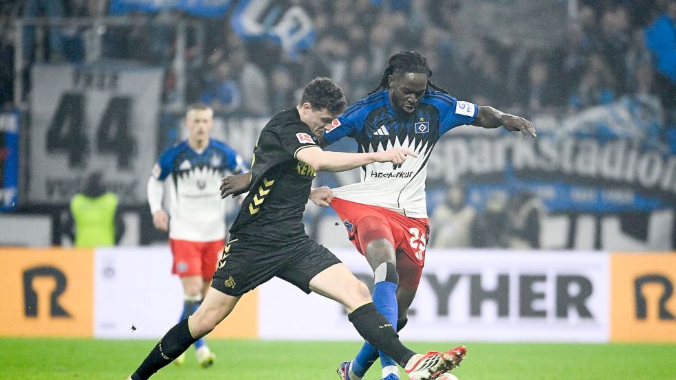 Kölns Eric Martel (l-r) und HSV-Abwehrspieler Jordan Torunarigha kämpfen um den Ball. Foto: Gregor Fischer