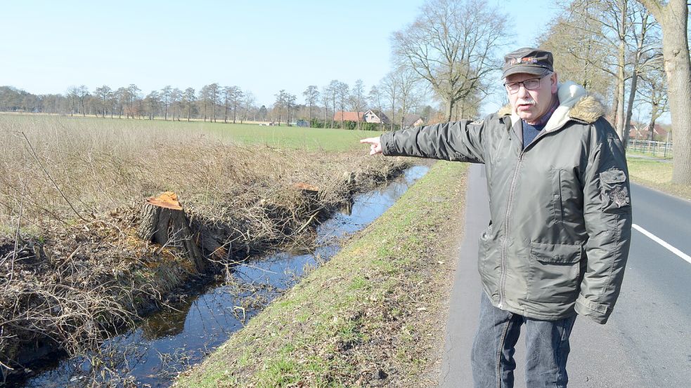 Empört zeigt Heinz-Hermann Siemer auf die abgesägten Bäume entlang der Brunzeler Straße. Täglich geht Siemer, der dem Burlager Ortsrat und der Freiwilligen Feuerwehr angehört, mit dem Hund an der Straße entlang. „Traurig ist das“, findet der 65-Jährige angesichts der Baumstümpfe. Foto: Astrid Fertig