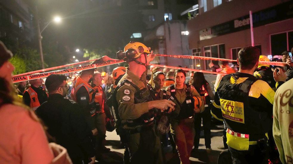 Sicherheits- und Rettungskräfte eilen zu der Einschlagstelle. Foto: Ohad Zwigenberg/AP/dpa