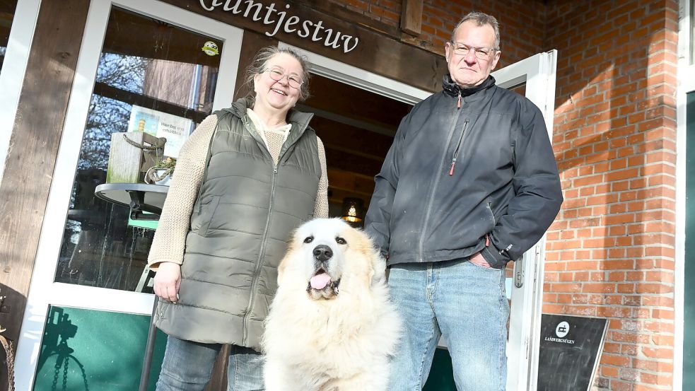 Gudrun Boschatzke, Peter Zitting und Hofhund Focko vor ihrem Café Kluntjestuv im Nienhof. Den Ort verbinden sie mit ganz besonderen Erinnerungen. Fotos: Heinz Wagenaar