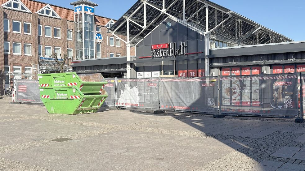 Das Café Extrablatt auf dem Auricher Marktplatz ist von Bauzäunen umringt. Schuttcontainer stehen vor den Türen und es wird eifrig an der Instandsetzung des Ladenlokals gearbeitet. Foto: Mieke Matthes