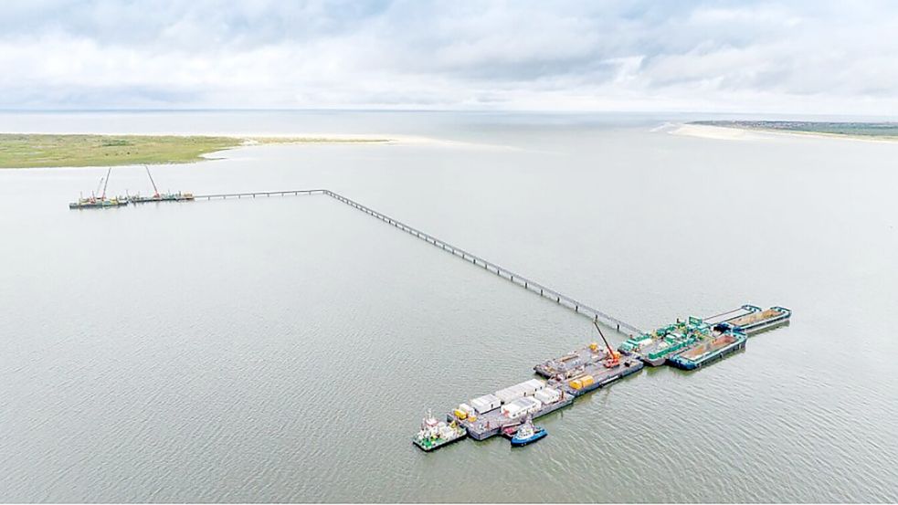 Im Watt zwischen Dornumersiel und Baltrum sind zwei miteinander verbundene Pontons entstanden. Auf dem kleineren näher an der Insel sind die Bohrgeräte, auf dem größeren ist eine Art Mini-Hafen eingerichtet, mitsamt Bürocontainer und Arbeitsflächen. Dazwischen verläuft ein rund 700 Meter langer Steg, der als Fußweg und auch für Versorgungsleitungen genutzt wird. Foto: Tennet