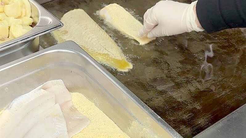 Der Fisch wird frisch paniert und gebraten. Foto: Stephanie Tomé