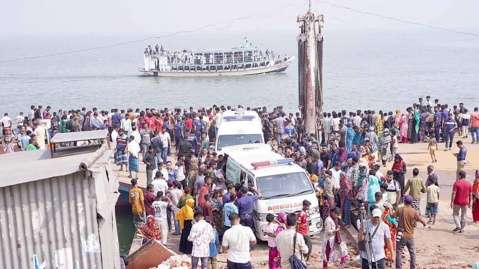 Rettungskräfte und zahlreiche Menschen versammeln sich an einer Unfallstelle, nachdem ein Bus in den Fluss Padma stürzte. Foto: Rubel Karmaker