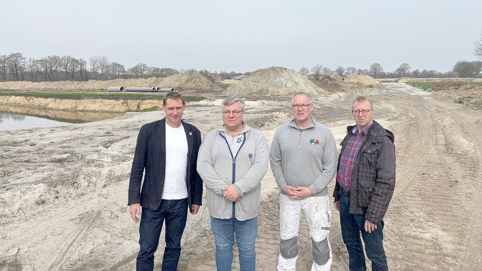 Bürgermeister Heinz Trauernicht (von links), Ortsvorsteher Reinhard Theen und Stephan Milfs sowie Bauamtsleiter Hinrich Becker stehen auf der Fläche, die aktuell in Jübberde erschlossen wird. Foto: Lars Löschen