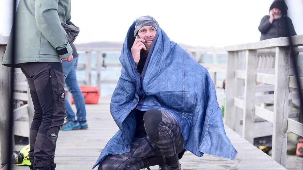 Robert Marc Lehmann geht auf Tuchfühlung mit einem gestrandeten Wal in der Ostsee. Foto: Daniel Bockwoldt