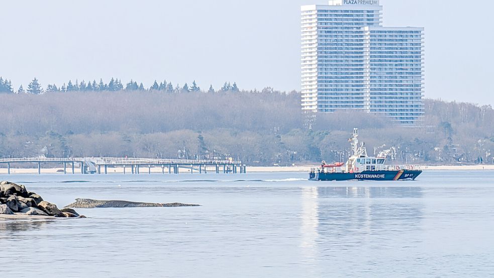 Seit Sonntagabend ist der Wal in Niendorf am Ostseeufer gestrandet. Sein Körper sticht kurz vor der Seebrücke am Hafen leicht aus dem Wasser hervor. Jetzt soll ihn ein Bagger aus seiner Lage befreien. Foto: Hans-Jörg Meckes