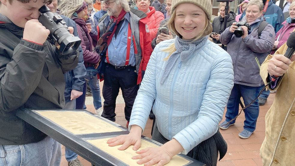 Schauspielerin Sofie Eifertinger mit ihren Handabdrücken in der Wittmunder Fußgängerzone. Foto: Imke Oltmanns