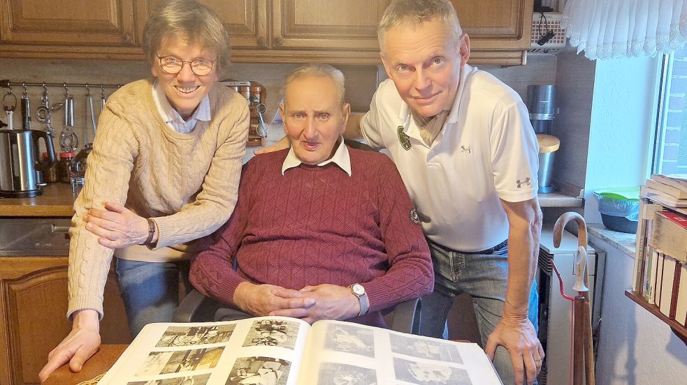 Pastorin Gretchen Ihmels-Albe, Heinrich de Boer und Rainer Wallek, ebenfalls Mitglied im Arbeitskreis des Dorfvereins, sehen sich eines der alten Fotoalben an. Foto: Tatjana Gettkowski