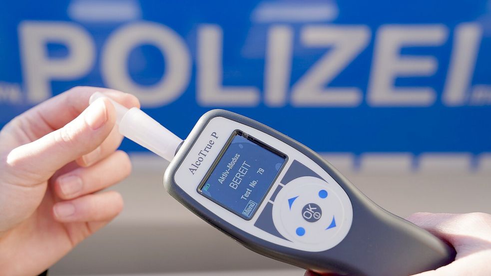 Ein Polizist hält ein Atemalkohol-Messgerät zur Überprüfung der Fahrtüchtigkeit eines Autofahrers in der Hand. Foto: DPA