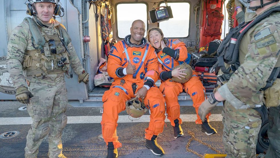 Die Astronauten Victor Glover und Christina Koch sitzen auf einem Hubschrauber der Navy auf dem Flugdeck des Schiffs USS John P. Murtha, nachdem sie aus ihrem „Orion“-Raumschiff geholt wurden. Foto: Bill Ingalls/NASA/AP/dpa