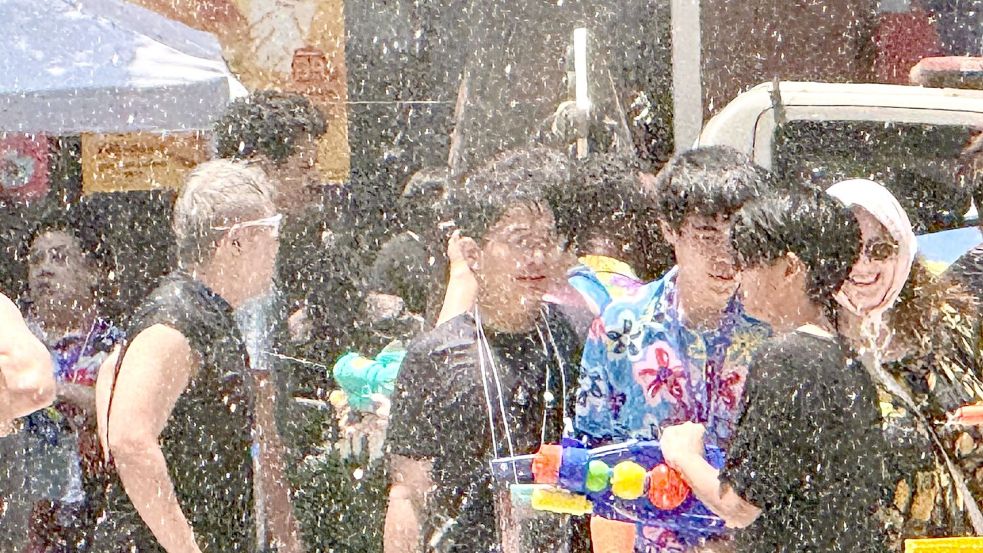 Einheimische und Touristen feiern traditionell zusammen - die meisten sind nach wenigen Minuten klatschnass. Foto: Carola Frentzen/dpa