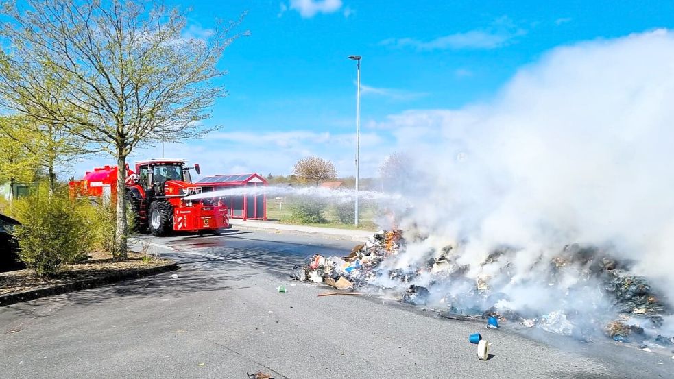 Der Einsatztraktor löschte den brennenden Restmüll auf dem Kaufhaus-Parkplatz bei Behrends in Wiesmoor. Foto: Jan-Marco Bienhoff