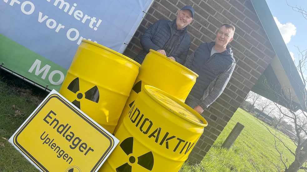 Claus Garrels (links) und Uwe Buscher befürchten ein Atommüll-Endlager in Uplengen. Diese Atommüllfässer sind allerdings nicht echt. Foto: Lars Löschen
