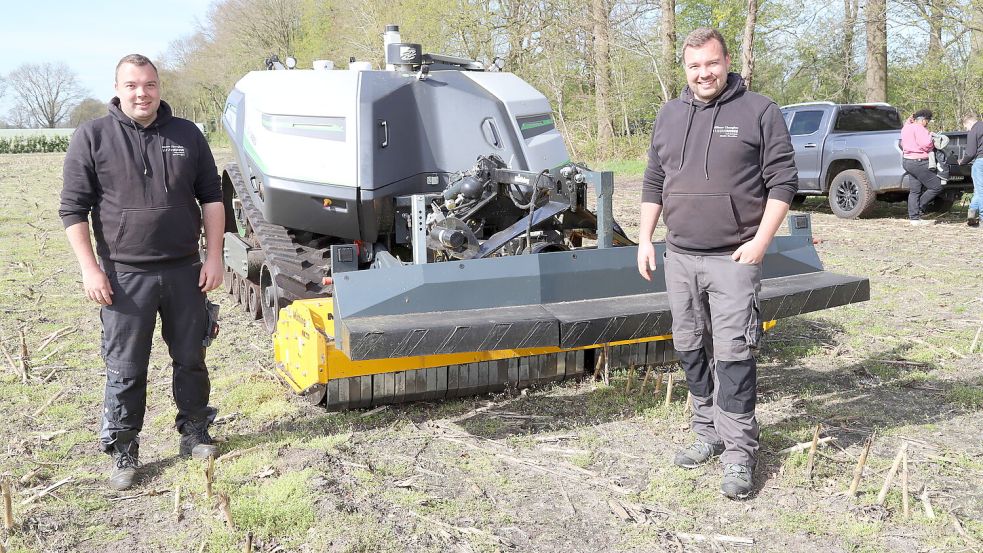 Auf einem Acker an der Lohorster Straße in Harkebrügge führten die Brüder Jan (links) und Mathes Thomßen Landwirten und Interessierten den autonomen Feldroboter AgXeed AgBot T2 (230) vor. Foto: Hans Passmann