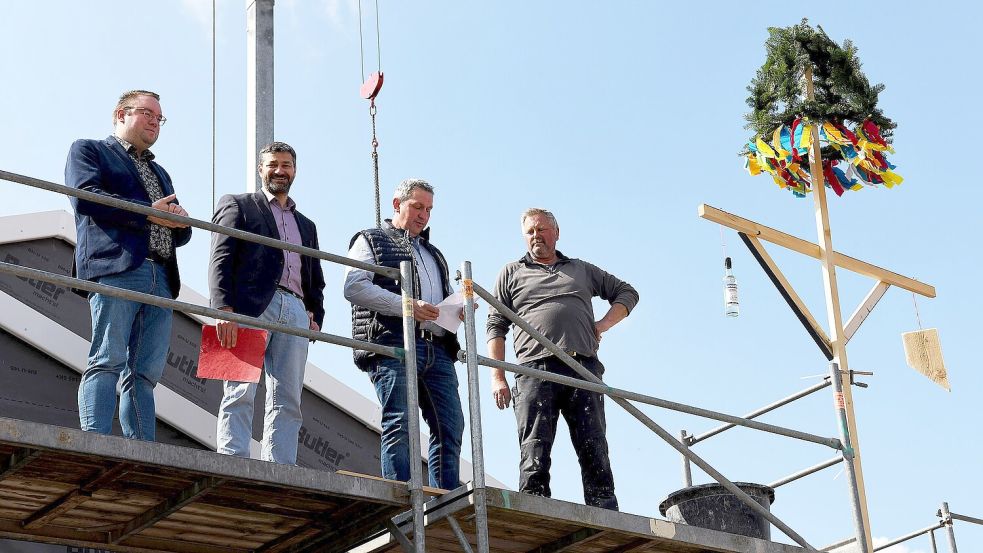 Deterns Bürgermeister Ruben Grüssing (von links), Samtgemeindebürgermeister Christoph Busboom, Bauunternehmer Karl-Heinz de Buhr sowie dessen Mitarbeiter Uwe Hinrichs hielten die obligatorischen Ansprachen auf dem Dach der neuen Mensa bei der Grundschule Detern. Foto: Melchert Stromann