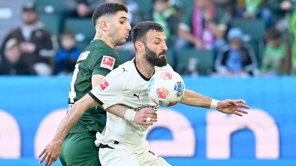 Im Zweikampf: Gladbachs Franck Honorat (r) wird vom Wolfsburger Konstantinos Koulierakis bedrängt. Foto: Swen Pförtner/dpa