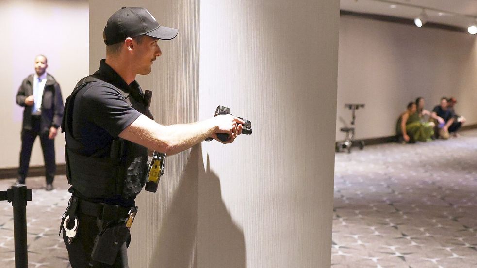 Sicherheitskräfte überwältigen den Mann. Foto: Tom Brenner