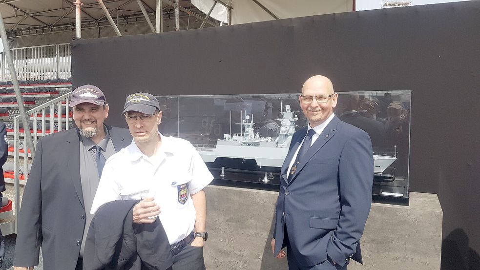 4. Mai 2023: Drei Mitglieder der BGEF – Franz-Joseph Neumeier, Tanjev Stuhr und Olaf Lemke – bei der Taufe der Korvette „Emden“ (F266) vor einem Modell der Korvette in Hamburg bei Blohm&Voss. Zur Taufe war die BGEF mit eingeladen und war mit einer sehr starken Mannstärke vertreten. Foto: Harald Idschinski