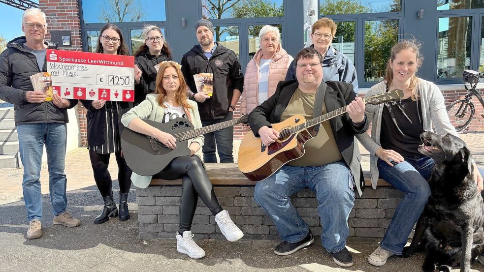 Freuen sich auf tolle Markttage: Helwig Weber (stehend von links) vom Förderverein Tourismus Rhauderfehn, Nicole Bussmann von der Sparkasse Leer-Wittmund, Gina Fahnster und Matthias Ksienzyk (Duo Gina & MaKs), Henni Bohlen vom Lütje Laden, Kunsthandwerkerin Amkeline Jans, sowie (vorne von links) die Musiker Anne de Vries und Christian Mettin und Jessica Beld vom Freundeskreis der Gemeindebüchereien mit „Bücherhund“ Balu. Foto: Marion Janßen
