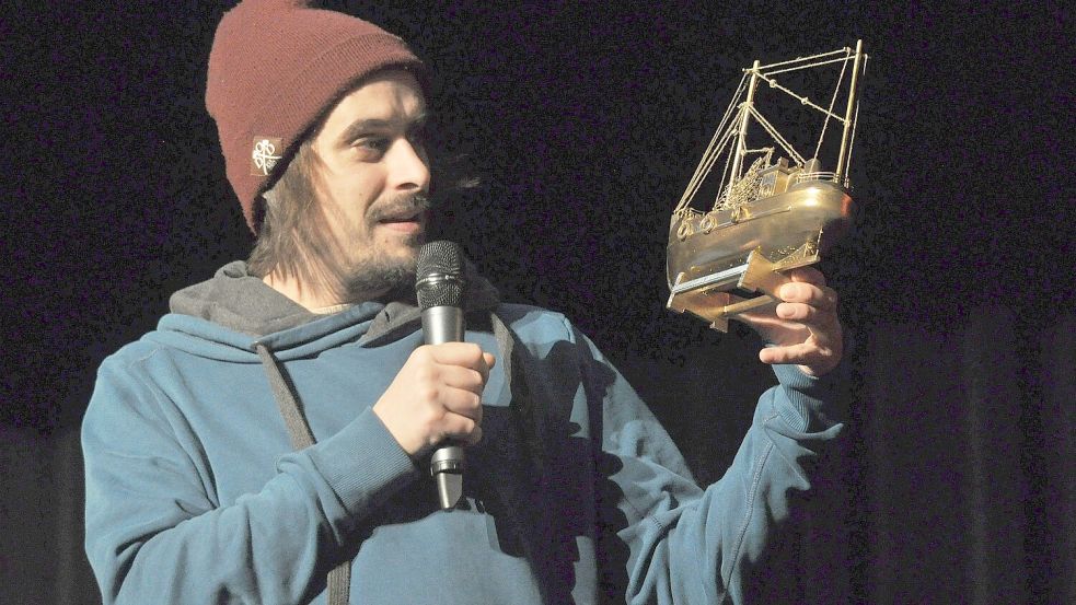 Moderator Andy Strauß hält die Trophäe des Slams: den goldenen Kutter. Foto: Veranstalter