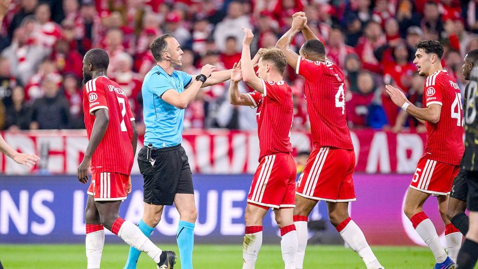 Die Bayern-Profis Joshua Kimmich und Jonathan Tah (M) bestürmen aufgebracht Schiedsrichter João Pinheiro. Foto: Tom Weller