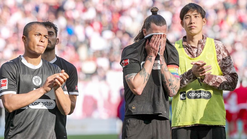 Anspannung im Abstiegskampf: Die Spieler des FC St. Pauli mit Kapitän Jackson Irvine (m) nach der Niederlage in Leipzig. Foto: Jan Woitas