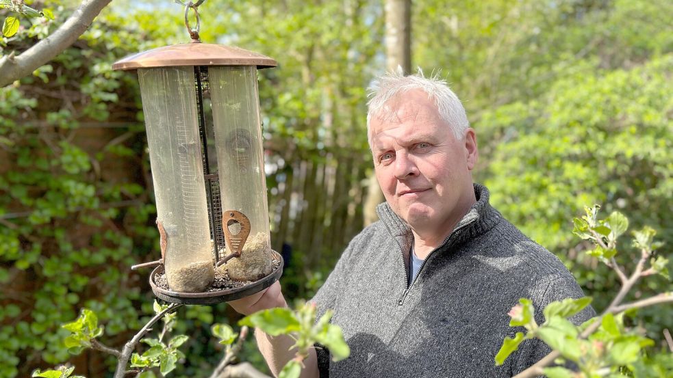 Schädlingsbekämpfer Harbert Poppens steht in seinem Garten neben einem Vogelfutterspender. Dieser ist rattensicher angebracht, sagt er. Foto: Lars Löschen