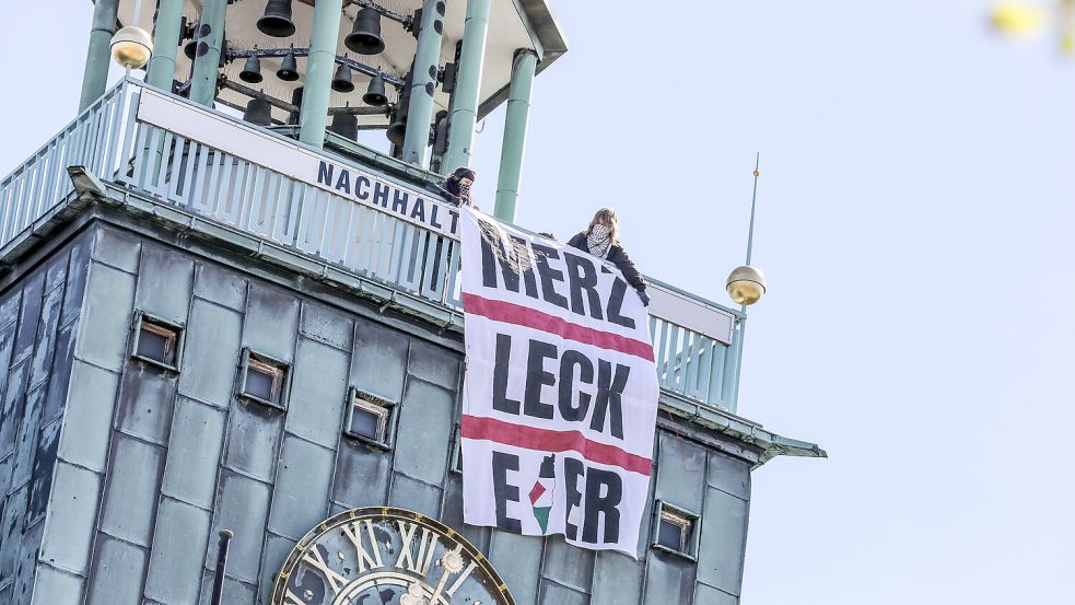 Ein Plakat mit der Aufschrift „Merz leck Eier“ hatten Aktivisten aus Oldenburg am Tag des Kanzlerbesuchs vom Emder Rathausturm hängen lassen. Das „i“ zeigt eine Palästina-Karte ohne Israel. Foto: Claus Hock/Archiv