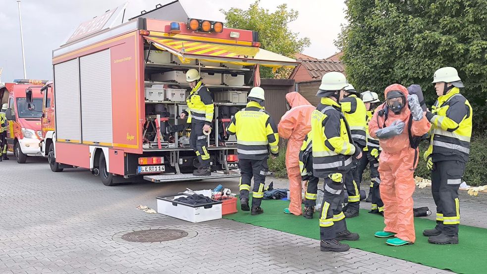 Vorbereitungen zum Betreten des Gebäudes: Feuerwehrleute aus Leer legen ABC-Schutz an. Foto: Daniel Grüneke