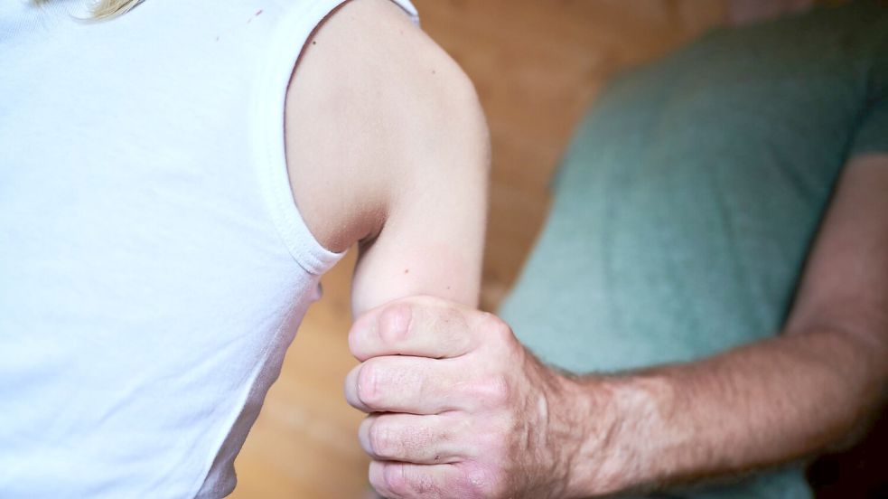 Ein Mann hält ein Kind fest am Arm (gestellte Szene). (Symbolbild) Foto: Annette Riedl