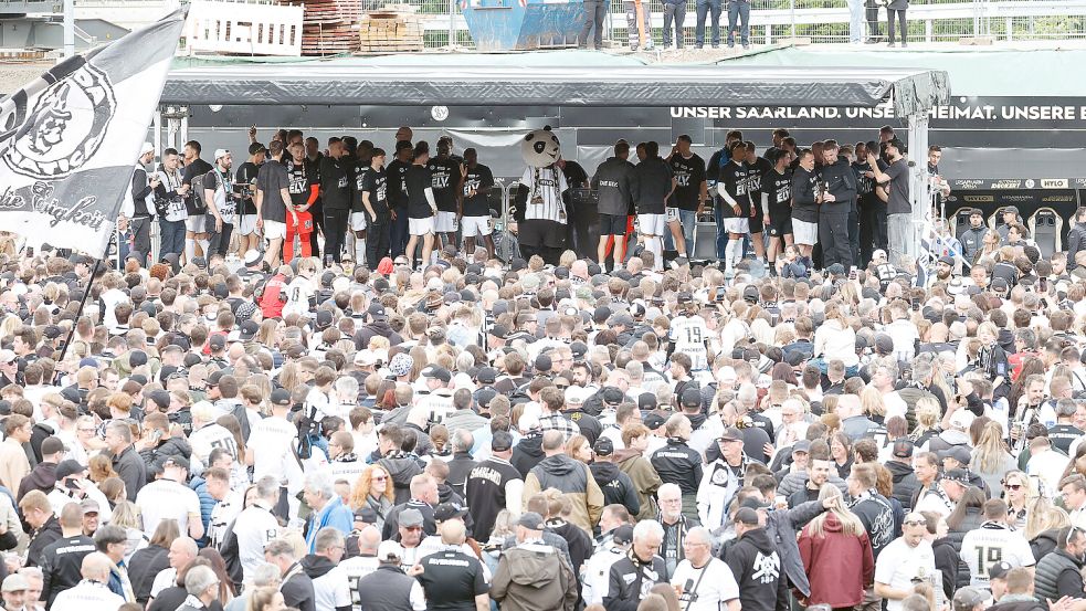 Riesige Freude über die Fußball-Sensation: Fans und Mannschaft feiern im Stadion den Bundesliga-Aufstieg der SV Elversberg. Foto: IMAGO/Jan Huebner