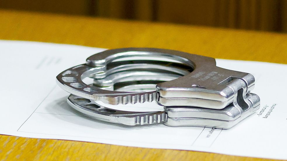 Handschellen liegen auf einem Tisch bei einem Prozess. Vor dem Auricher Landgericht ging es um Raubüberfälle in Emden. Foto: dpa/Frank Molter